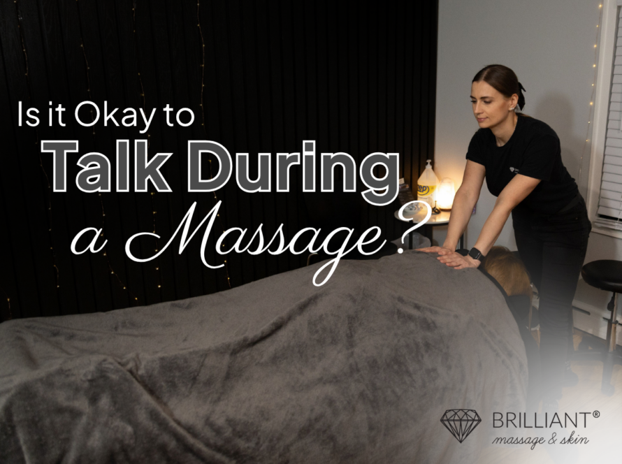 A therapist giving an upper back massage a client lying on a massage table covered by a brown sheet. Text saying "Is it Okay to Talk During a Massage?"